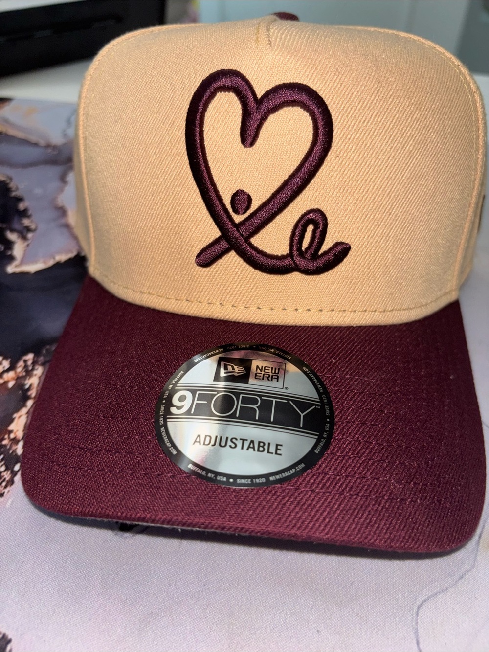 New Era two-tone cap in tan and burgundy with heart logo